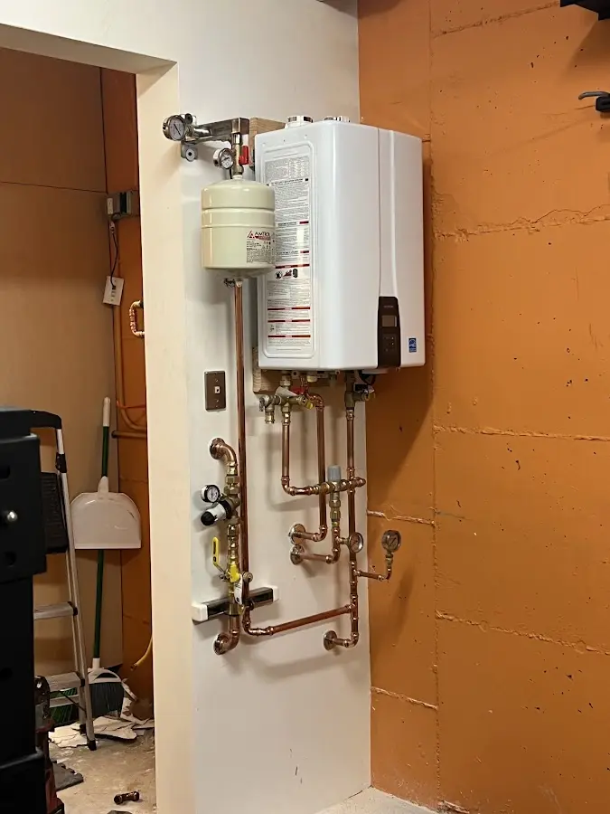 Plumbing technician inspecting water heater connections in Grosse Pointe Park